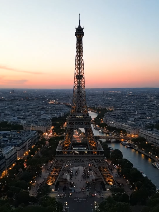 Eiffel Tower Sunset Cinematic View For this #WeekendWandering, we're transported to the romantic heart of Paris, France, at sunset. The Eiffel Tower, an enduring symbol of love and architectural marvel, truly comes alive as the city lights up. Our slow drone orbit aims to capture the magical ambiance that makes Paris a timeless destination.  #AI #Paris #EiffelTower #RomanticCity #VirtualVoyager