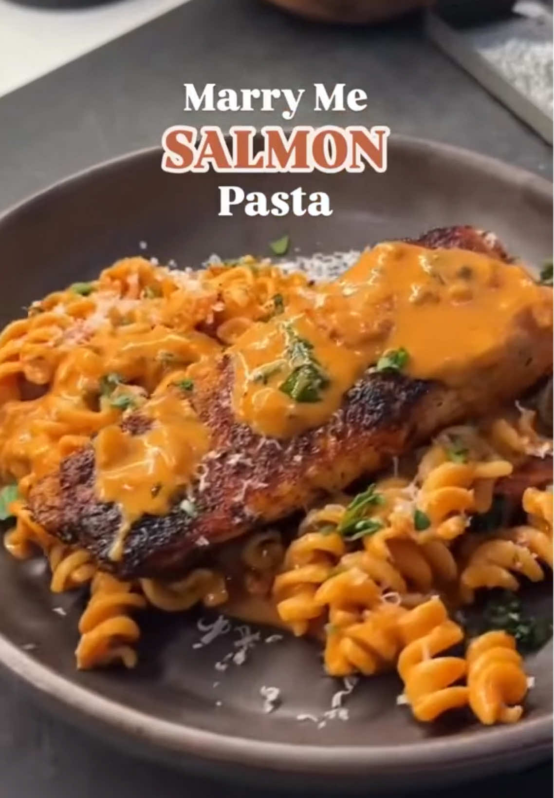 MARRY ME SALMON This is going to be one of the most incredible pasta and salmon dishes you’ll ever have. You’ve heard of the viral marry me chicken, but lets switch things up with something even better - this marry me salmon is so easy to make, so delicious, and SO good. The salmon is phenomenal on its own, but its always better with some high protein lowcarb pasta. I used my @Kaizen Food Company pasta for this, but you can use any pasta you prefer. Here is how I made it (makes 4-5 servings) 1 Start by seasoning 1lb of salmon filets.Lay them out on parchment paper or board and season with a couple pinches salt, fresh cracked pepper, 1 tbsp onion powder, 1 tbsp garlic powder, 1 tbsp sweet paprika, 1/2 tbsp thyme, and 1/2 tsp cayenne pepper. Distribute evenly over the salmon filets and set aside. 2 Bring a pan on medium heat and cook the salmon for about 3-3.5 minutes on each side. Set aside. 3 Now lets make the sauce. Finely dice 1/2 large yellow onion. Add it to a pan on medium heat with 1 tbsp oil or butter and 1 tbsp water. Then season with salt, pepper, and 1 tsp thyme. 4 When the onions turn translucent, add 2 tbsp tomato paste, 3/4 cup cream, 3/4 cup bone broth, and mix well with a spatula until it cooks down to a beautiful orange color. 5 Add 1/2 cup sundried tomatos, a large handful of fresh basil and turn off the heat. Reserve some of sauce (about 1/3 to 1/2 cup) 6 You can serve this with rice, quinoa, or pasta. I served it with my lowcarb high protein  @KaizenFoodCompany   pasta. I used the fusilli shape, boiled the pasta in generously salted water for 4 minutes, strained, rinsed, and added it to the pan with the sauce and mixed it well. 7 When you’re ready to eat, plate up the pasta, top with a salmon filet, some fresh basil, and freshly shredded pecorino or parmesan cheese. Add some more of that sauce (optional) on top and devour! ENJOY! #lowcarb #lowcarbrecipes #keto #ketorecipes #healthyrecipes   