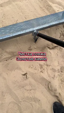 Чистка пляжа совком от золотых камней из песка