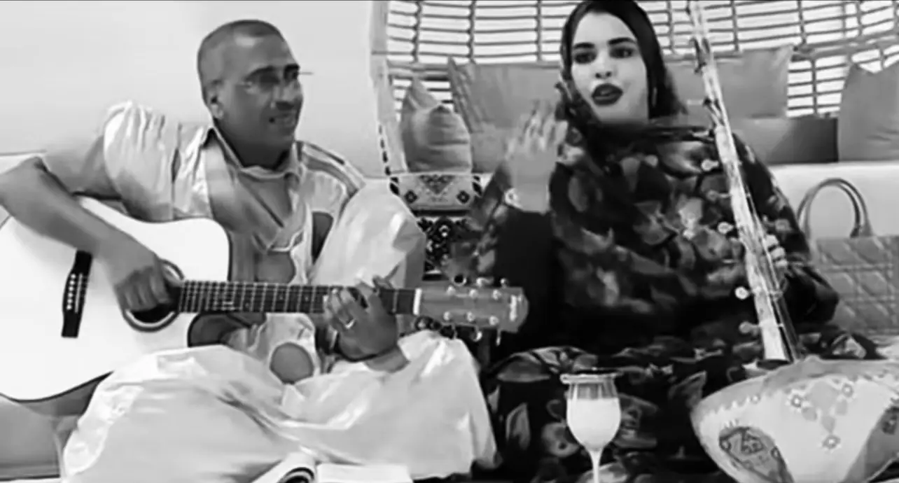 القصيدة التي بين أيدينا من روائع الشعر العربي الكلاسيكي, تنبض بالصور البلاغية المدهشة وتكشف عن قلب مكلوم لا يجد للتعبير سوى الدمع والأنين فيقول إن الدموع تجيبه بدل القلب وإنّ بين أضلعه دمًا ولحمًا لا يحتمل ثقل ما يعانيه لغة القصيدة عميقة، وإيقاعها شجي وتلامس وجدان كل من عرف معنى الفقد واللوعة. وإذا انتقلنا إلى عالم الفن فإننا نجد في الأداء الغنائي من طرف الثنائي گرمي منت أبه و سيداتي ولد سدوم صدىً لهذه الروح الشعرية لقد قدّما الغناء الحسّانِي بروح جديدة مزجت بين الأصالة والحداثة، وأثبتا أن الفن ليس مجرد تقليد بل هو إعادة خلق وإضافة بصمة شخصية تُميّز الفنان عن غيره. ولا يخفى أنّهما مهما بلغا من الإبداع يظلّ تقليد قمم مثل سدوم ولد أيده و ديمي منت أبه أمرًا مستحيلاً، لأن هؤلاء الأسماء أسّسوا مدرسة متفرّدة في الأداء الحسّاني، مدرسة لا تُكرّر ومع ذلك فإن الثنائي گرمي وسيداتي لم يبخلا على الساحة الفنية بالعطاء بل قدّما لونًا مكمّلًا للتراث فأصبحا هما أيضًا رقمًا صعبًا لا يمكن تجاوزه يضاف إلى سلاسل الفن الأصيل في موريتانيا. ويسأل في الحوادث ذو صواب فهل ترك الجمال له صوابا وكنت إذا سألت القلب يومًا تولى الدمع عن قلبي الجوابا ولي بين الضلوع دمٌ ولحمٌ هما الواهي الذي ثكل الشبابا تسرّب في الدموع فقلت ولّى وصفّق في الضلوع فقلت تابا ولو خلقت قلوب من حديدٍ لما حملت كما حمل العذابا ولا ينبئك عن خلق الليالي كمن فقد الأحبة والصحاب #Mauritania #fyp #foryou 