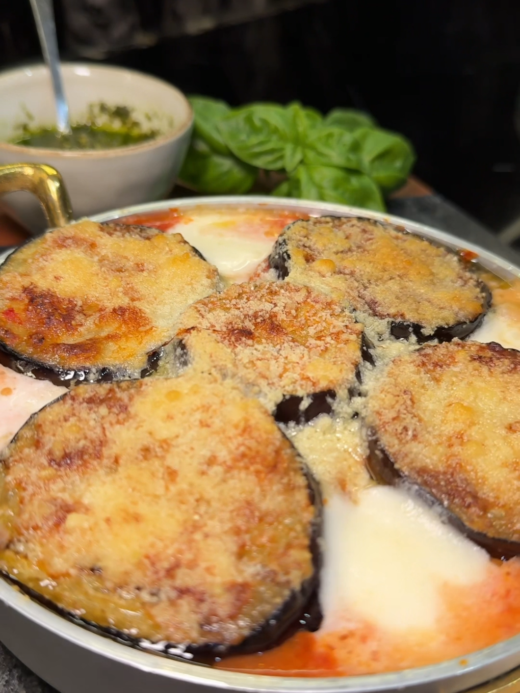Grilled Eggplant Parmesan with Pesto
 Ingredients:
 • 1 eggplant (aubergine)
 • 2 tomatoes
 • 2 fresh mozzarella balls
 • 3 tbsp pesto sauce
 • 30 g (1 oz) Parmesan cheese, grated
 • 1 sprig fresh basil
 • 150 ml (5 fl oz or ⅔ cup) marinara
 sauce
 • 2 tbsp olive oil
 Instructions:
 1) Slice the eggplant into round slices
 and grill on both sides on a grill pan until
 tender.
 2) Grease a baking dish with olive oil,
 then pour in the marinara sauce.
 3) Layer the grilled eggplant slices,
 followed by tomato slices, mozzarella,
 and another layer of eggplant. Sprinkle
 grated Parmesan on top.
 4) Bake in a preheated oven at 180°C
 (350°F) for 15-20 minutes.
 5) Remove from the oven, top with pesto
 sauce and fresh basil leaves. Serve warm. #sofiaafoodie #parmesan #eggplant  #pesto 