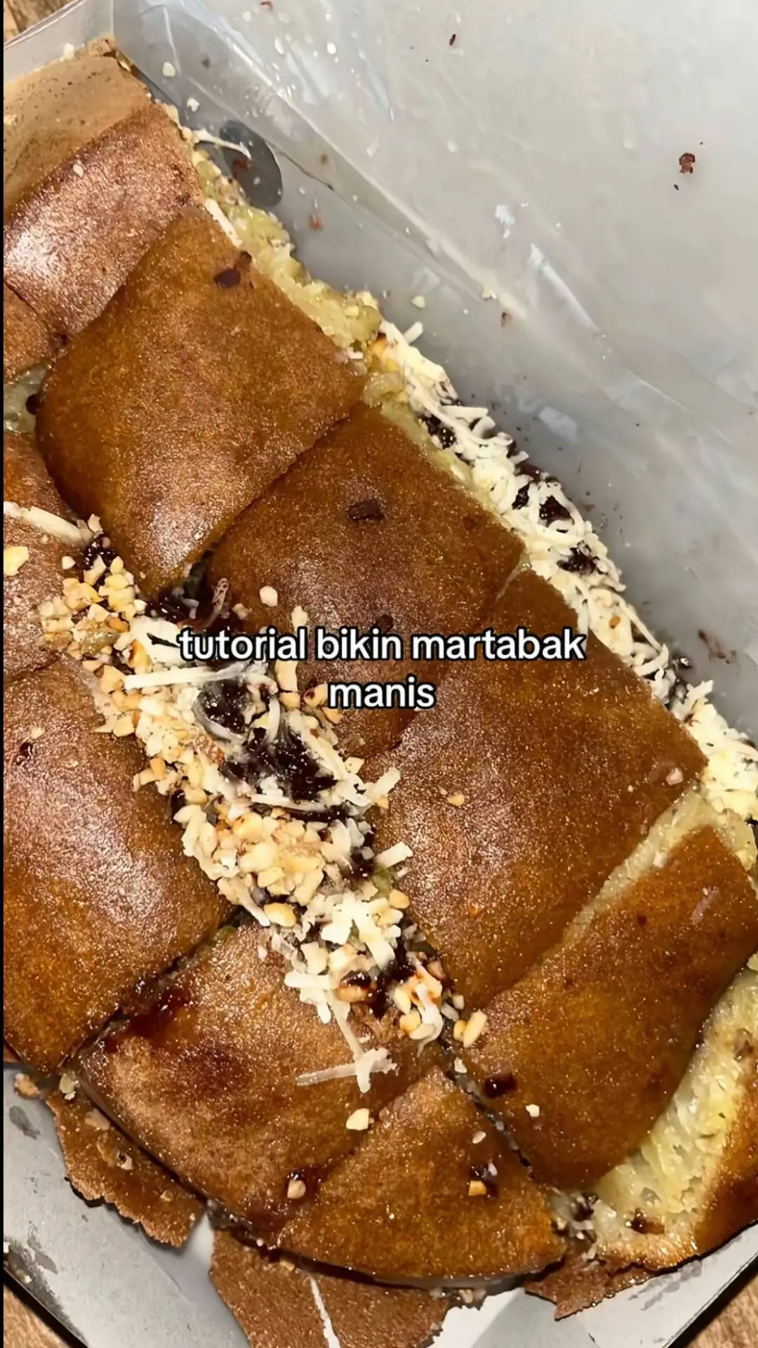 🐝CARA MEMBUAT MARTABAK MANIS DI RUMAH🍯 #trend  bahan: 1• 100 gr gula pasir  2• 450 gr tepung terigu 3• 3 butir telur  4• 1 sdt soda kue 5• sejumput garam 6• 500 ml air 7• ½sdt vanili 8• margarin secukupnya  Topping: 1• meses coklat 2• keju 3• susu kental manis cara membuat: -siapkan bahan.campurkan bahan kering seperti tepung terigu,gula,dan vanili kecuali soda kue serta telur di dalam wadah -diamkan 30 menit -tambahkan telur fan boking powder,kemudian mixer sebentar -jika sudah panaskan cetakan terlebih dahulu  -oleskanceyakan dengan margarin.kemudian tuangkan adonan.tunggu sampai keluar gelembung-gelembung kecil dan jangan ditutup terlebih dahulu. -jika adonan sudah berbuih dan agak kering,taburkan gula pasir,lalu tutup dan tunggu sampai matang -angkat dari cetakan,olesi dengan margarin di permukaan martabak.beri topping sesuai selera dan susu kental manis.  -lipat martabak manis,olesi dengan margarin,potong menjadi beberapa bagian. -martabak manis siap disajikan