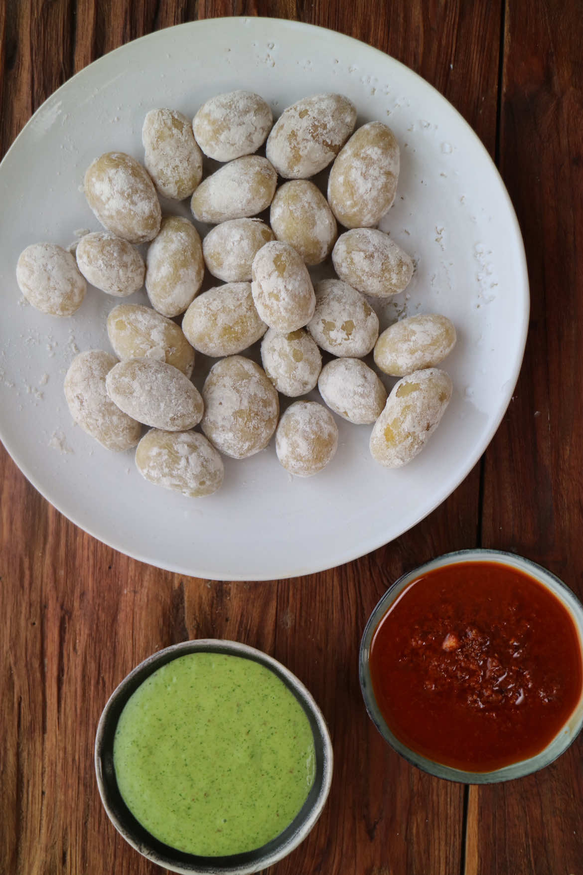 Papas arrugadas con mojo Si vas a las Islas Canarias comerás papas arrugadas una y otra vez. ¡Qué cosa más rica y sabrosa! En la península no es fácil conseguir sus típicas patatas, pero eso no impide que podamos hacer la receta en casa, bien fácil y económica. ▪️Ingredientes: 1 kg de patatas baby nuevas Agua (hasta cubrir) Un puñado de sal gorda Para el mojo rojo: 1 ñora 1-2 g de sal gorda 3 g de comino en grano 4 ajos 5 g de pimentón picante y dulce 2 cayenas 15 g de vinagre de vino blanco 70 g de aceite de oliva virgen extra Para el mojo verde: Un puñado de cilantro fresco 2 g de comino en grano 2 ajos Un trozo pequeño de pimiento verde (opcional) 1-2 g de sal gorda 15 g vinagre de vino blanco 70 g aceite de oliva virgen extra ▫️Necesitamos patatas pequeñas y de un tamaño regular, mejor si son nuevas. Las lavamos bien y las echamos en una olla sin amontonar. Echamos agua hasta cubrir y echamos un puñado de sal gorda por cada kilo de patatas. Ponemos a hervir a fuego fuerte sin tapar, necesitamos que se evaporen 3/4 partes de agua. Cuando quede 1/4 de agua vamos removiendo sin retirar del fuego en forma de vaivén, hasta que el agua se evapore totalmente y se cree la típica costra blanca en las patatas.  Preparamos el mojo rojo. Hidratamos la ñora 5 minutos en agua hirviendo, pasado el tiempo, limpiamos la carne de la ñora y la echamos en el vaso de la picadora junto con el resto de ingredientes, trituramos y listo. Para el mojo verde trituramos echamos todos los ingredientes en el vaso de la batidora, trituramos y listo. Presentamos nuestras patatas arrugadas en un plato o fuente y acompañamos con los dos mojos. #lasrecetasdemj #Receta #recetas #recetasfaciles #papasarrugas 