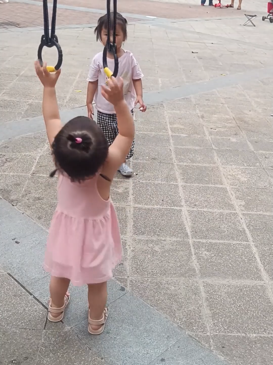 A 16-month-old girl is showing off her skills on playground rings, even creating her own moves and doing a split in mid-air – what a natural talent! #cute #funny