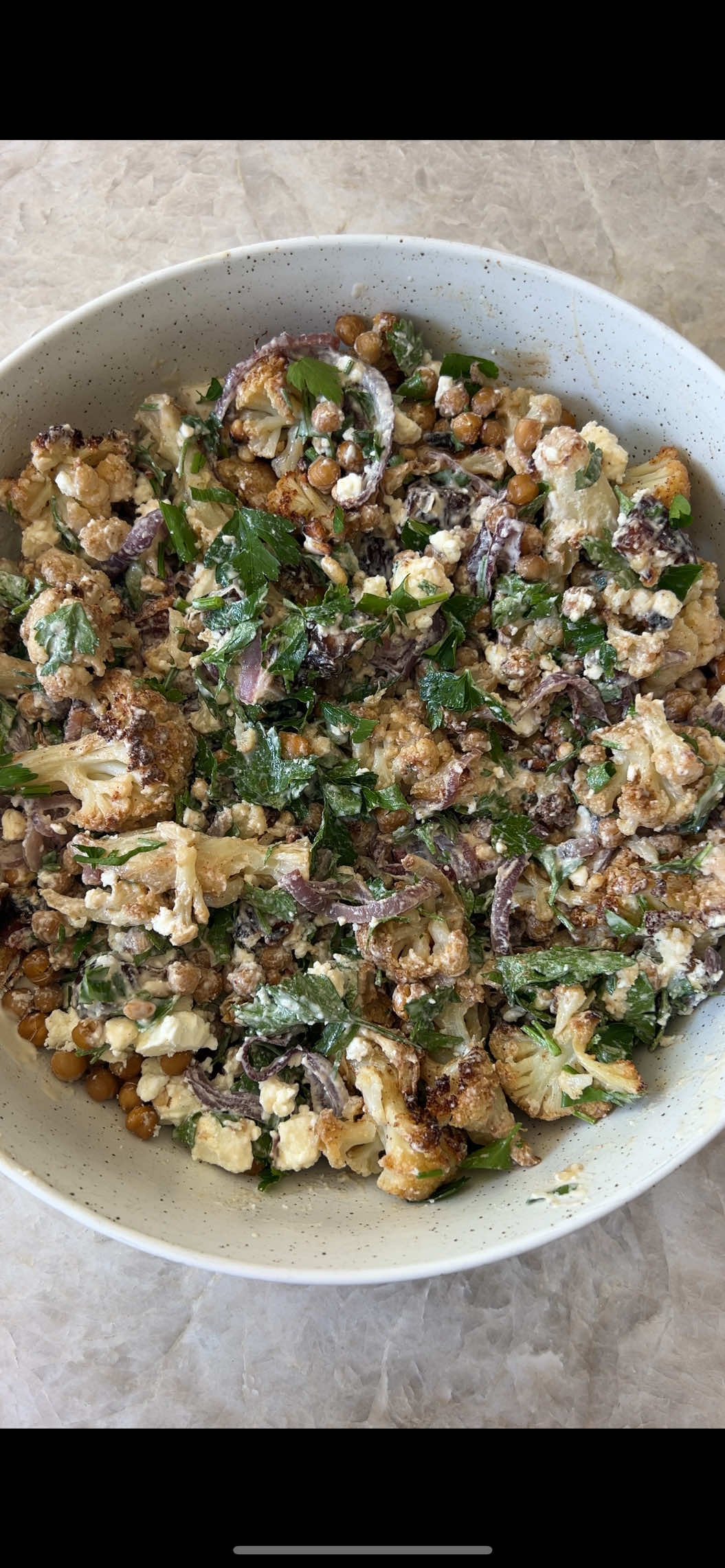 I’m a dietitian and this Roasted Cauliflower & Chickpea Salad is one of my favourite ways to fibre-max 🥦✨ So what is fibre-maxing? 🌾 It’s about deliberately adding as much fibre as possible into your meals and snacks - think veggies, legumes, wholegrains, fruit, nuts and seeds - to help you reach that 25–30g/day fibre goal most of us miss. Why fibre matters: ✅ Supports gut health ✅ Helps balance blood sugars ✅ Keeps you full & energised This bowl is the perfect example: roasted cauliflower, crispy chickpeas, onion, parsley, sweet dates and a little feta for flavour. Fibre + flavour = the ultimate salad combo. RECIPE For the Salad 1 head cauliflower, cut into small florets 1 can chickpeas, drained   1 red onion, sliced   2 Tbsp extra virgin olive oil  1 tsp cumin ½ tsp paprika  Pinch of salt  8 medjool dates, pitted & chopped ½ cup parsley, roughly chopped 150g feta, crumbled   ¼ cup pine nuts, toasted For the Dressing 3 Tbsp tahini  Juice of 1lemon 1 Tbsp extra virgin olive oil  2 Tbsp water  1 clove garlic, grated     Pinch of salt Method Preheat the oven to 180C & line a large baking sheet with parchment paper. Add cauliflower & onion & toss with oil & spices. Roast for 30 minutes, turning halfway through. Place into a large serving bowl with remaining ingredients. Whisk dressing ingredients together until smooth & pour over salad, toss to combine and enjoy.    Save this for your next meal-prep salad inspiration 💚 #fibremaxxing #fibermaxxing #saladbowl #dietitiantips #guthealth  