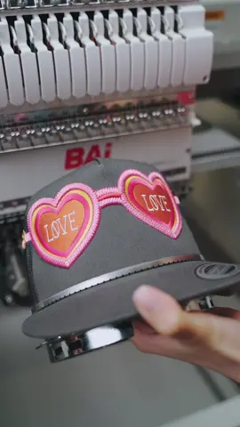 😎✨ Pink sunglasses embroidered right on the hat! With free rotation, the machine stitches smoothly from the side to the front, creating the full sunglasses design. Who says hat embroidery has to stay on the front? Side + front makes it extra unique! 🧵🧢 #baiembroiderymachine #embroiderymachine #customembroidery #SmallBusiness #embroiderywork 