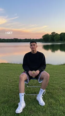 Gemini ai Prompt; Using the model, create an outdoor photograph of me taken in the late afternoon,In the photo,I am sitting on folding chair by a tranquil lake.Wearing a black sweatshirt.wearing red Nike shorts and white sneakers with white socks.Holding a golden-colored beverage can.Background,A vast lake with the reflection of the sky.a clear evening sky with thin clouds . There are Trees on the opposite side of the late.They are sitting on well-kept green grass.Photo Style, Outdoor Portrait, casual style, with natural dusk lighting.The overall impression is relaxed and peaceful. #CapCut #followerstiktok #gemini #fyp 