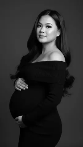 Gemini Al maternity shoot prompt.. Step  1: Open your Gemini Al                         Step 2: Upload your photo Step 3: Copy this text/prompt Prompt: A full-length black and white maternity portrait of me with long, smooth, dark hair parted slightly off-center, styled in soft waves. She's standing sideways with her face looking forward, softly smiling. She wears a black off the shoulder fine knit sweater dress with dreamy and luxurious feel. Her makeup is still in place - soft glam with winged eyeliner, full lashes, and a subtle glow. She's gently caressing her baby bump with both hands. The background is dark gray with soft studio lighting to highlight her features, and the image is high-resolution, 360 HD, editorial style, with emphasis on natural beauty and elegance.