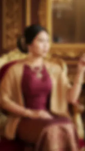ကြိုက်နေပြီ🥰 မိမိုက်နေရော  #gemini ai prompt:Ultra-realistic full-body portrait of a Burmese woman in elegant traditional dress, seated gracefully on an ornate gilded armchair inside a luxurious antique interior. She wears a deep maroon silk top, a patterned gold and red silk longyi, and a tan shawl-style jacket with a jeweled brooch. Her hair is styled in a classic updo with a golden hair ornament, and she wears intricate gold jewelry. She sits with legs crossed elegantly, facing the camera directly with her body and head turned forward for a straight-on composition. Her right hand is raised holding a slim cigarette holder, while her left hand rests naturally on her lap. Her expression is serene and regal. Warm cinematic lighting with a soft golden glow, 8K ultra high resolution, shallow depth of field, fine silk fabric details, ornate carved golden background, photorealistic, professional editorial photography. #ရောက်ချင်တဲ့နေရာရောက်👌 #fyp #foryou #မေမြို့သူ 