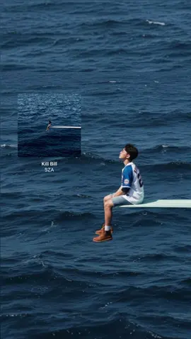 From my fav singer // SZA Vibes.                                               Prompt 🌊 👉🏻  Use this picture to create A lone figure sits contemplatively on a diving board extending over a vast, deep blue ocean with choppy waves. The person has dark, curly hair and is wearing an oversized sports jersey with 