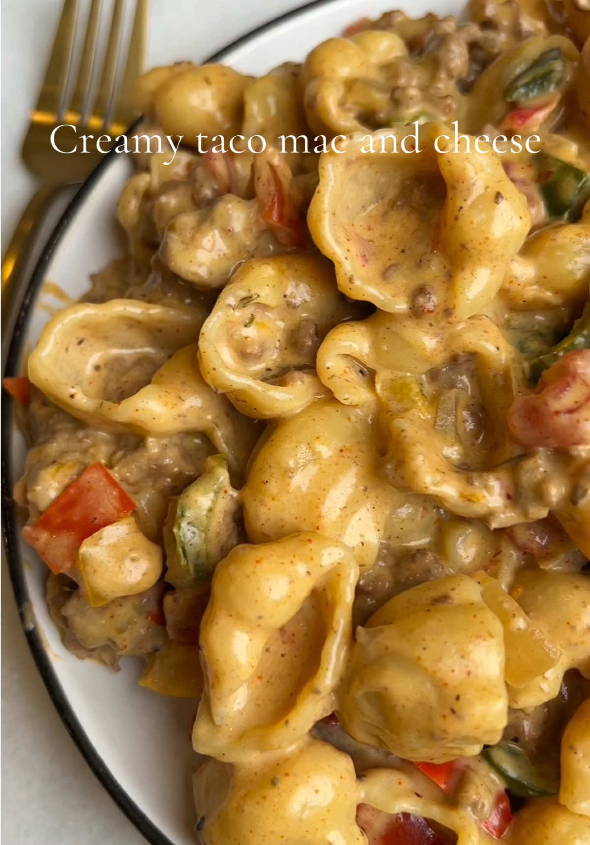 Creamy taco mac and cheese! Recipe is linked.  Creamy and indulgent, this taco mac and cheese is a comforting dish loaded with ground beef, peppers, onions, and tender pasta. Everything is tossed in a rich, cheesy, taco-seasoned cream sauce, making for one seriously comforting meal!  #tacomac #pastarecipe #fallrecipes #macandcheese #dinnerinspo 