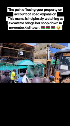 : This mama is helplessly watching as  excavator brings her shop down in mwembe,kisii town.