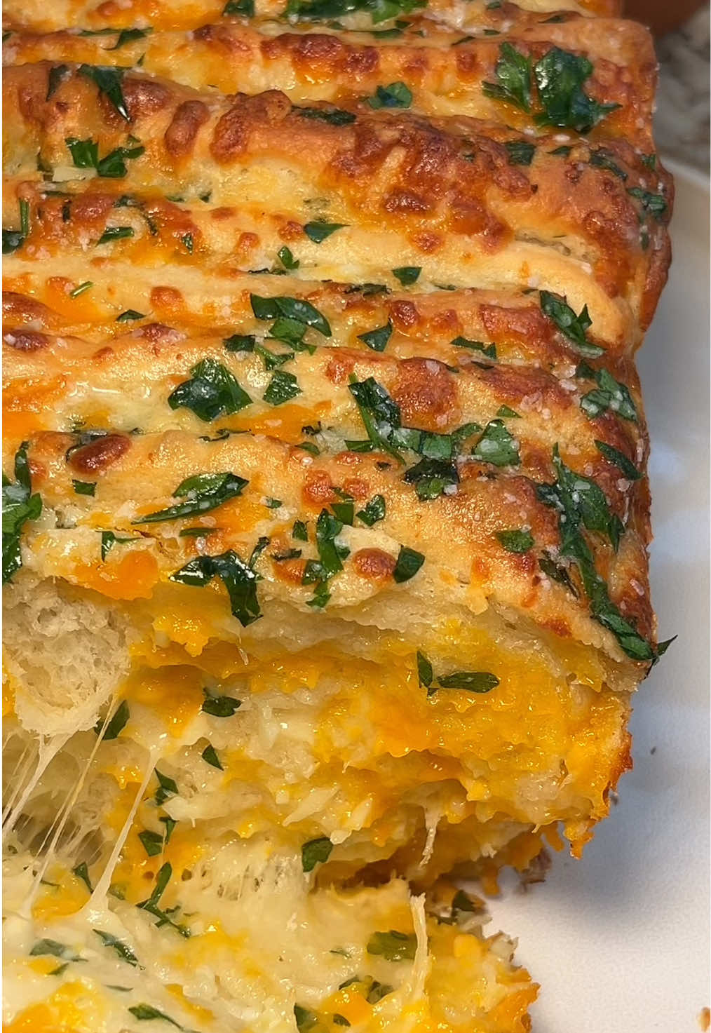 Cheesy garlic herb pull apart bread 🧀🍞💚 are you a fan of garlic bread? Well this is for you! Perfect for sharing or hoard it for yourself 😉 Makes one, 9x5 inch loaf pan Dough * 7g active dry yeast * 12g granulated sugar * 180g whole milk, warm to 110F * 1 large egg * 330g all-purpose flour plus more more kneading  * 6g salt * 4g garlic powder * 43g unsalted butter, softened Garlic herb filling * 100g unsalted butter, softened * 1 tablespoon garlic, finely minced * 1 tablespoon parsley, chopped * ½ teaspoon kosher salt * 113 g mozzarella cheese, shredded * 55g sharp cheddar cheese, shredded * 55g white cheddar cheese, shredded Butter herb topping * 1 tablespoon unsalted butter, melted * 1/2 tbsp parsley, chopped * kosher salt, for garnish #garlicbread #breadtok #bakingrecipe #garlic #bakingtiktok 