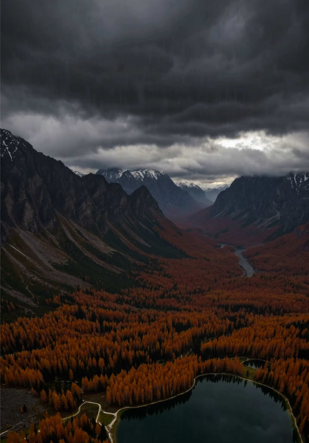 🌧✨ POV: You’re standing atop a snow-capped mountain on a gloomy autumn evening, watching heavy rain sweep across a valley glowing with fiery orange and deep red trees. A glass-like lake lies below, mirroring the stormy sky as gentle ripples form where raindrops fall. Dark overcast clouds crown the rugged peaks, creating a breathtaking mix of drama and calm. Perfect for anyone who loves mountain rain vibes, soothing nature sounds, and cozy fall landscapes. 🏔🍂☔⛈️💧✨🍁 #rainydayvibes #rainasmr #sleepasmr #relaxingrain #rainonme 