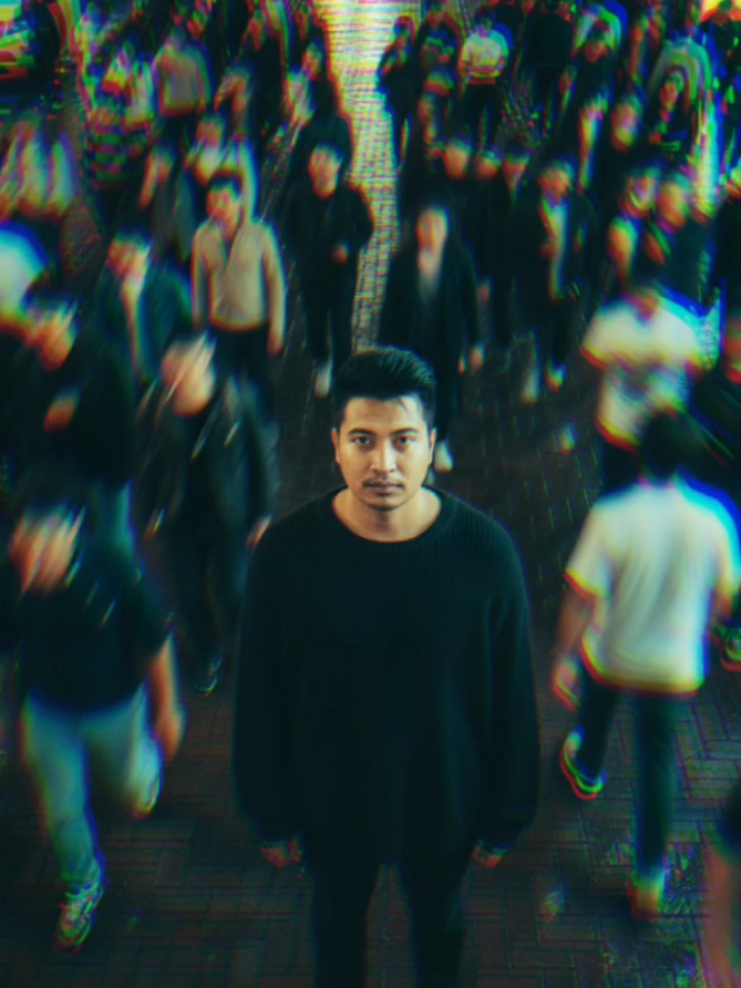 PROMT 1. 1. OPEN GOOGLE 2. OPEN GEMINI AI 3. TEMPEL PROMPT : A high-angle photograph of a young man in a black sweater standing perfectly still on a brick-paved street at night. He is in sharp focus, looking directly at the camera. Around him, a dense crowd of people is walking, captured with motion blur to create a sense of movement and chaos, contrasting his stillness. The scene is illuminated by neon and city lights. #fyp #ai #fotoai #hitam 