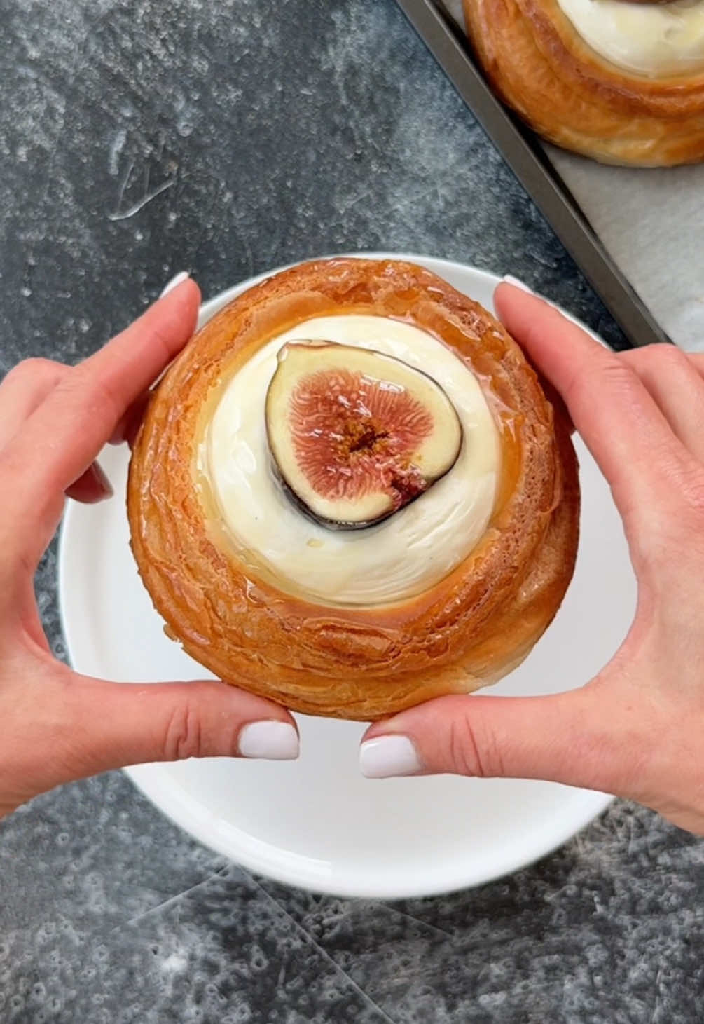 Juicy figs, homemade fig compote whipped crème fraiche custard filled croissant danishes:  👉 The croissant dough recipe is on my website — I did 3 single folds, rolled to 9 mm, cut 9 cm circles, proofed, and baked with weights on top to create little wells for the filling. Here’s how I finished them: Fig Compote 🍇 	•	200 g fresh figs (quartered) 	•	50 g sugar 	•	2 tbsp water 	•	1 tbsp lemon juice + zest of ½ lemon 	•	Optional: vanilla or cinnamon Simmer everything on low until figs soften (10–15 min). Mash lightly for a rustic compote, or blend smooth. Chill before using. Whipped Crème Fraîche Custard 🍮 	•	300 ml milk 	•	3 egg yolks 	•	60 g sugar 	•	15 g cornstarch 	•	200 g crème fraîche 	•	1 tsp vanilla Cook milk, yolks, sugar & cornstarch into a thick custard. Off heat, whisk in crème fraîche & vanilla. Chill, then lightly whip until airy. ✨ To assemble: Layer in fig compote → pipe in whipped custard → top with fresh fig slices → finish with a drizzle of honey. #fig #danish #Recipe #custard #delicious 