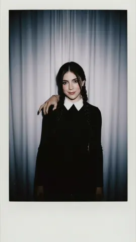 Merlibaliz Addams 👧🏻🕯️🖤 🕷🕸️ App: Gemini Prompt (razanlkd en threads): Polaroid-style vintage photo. Keep my real face unchanged, natural, and realistic, with a slight blur and flash-like lighting in a dark room. Background: simple white curtain. I’m standing relaxed with a cute smile, wearing Wednesday Addams style (black outfit, two braids). Add Thing, the disembodied hand, on my shoulder. The photo should feel cute yet slightly eerie, like a whimsical snapshot with dark humor.