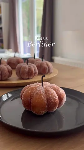 Diese Kürbisse sind nicht das, was du denkst! 🎃  Hefeteig:  1pck Trockenhefe  130ml Milch lauwarm  100g Flüssige Butter  30g Zucker  2 Eier  470g Mehl  Füllung: 250g Milch  1 EL Zucker  1/2 Pck Vanillepuddingpulver  Zucker zum wälzen  4 Vanilleschoten (eine in drei Teilen) 1. Alle Zutaten für den Teig gut verkneten und 1h abgedeckt gehen lassen. 2. Den Pudding kochen und abkühlen lassen.  3. In 12 Teilen und eine dünne Schnur viel mal um die Kugel wickeln und festbinden.  4. Die Kugeln nochmal 30min abgedeckt gehen lassen.  5. Öl in einem Topf auf 170C erhitzen, den Herd nach erreichen der Temperatur etwas runterschalten, weil es sonst immer heißer wird.  6. Die Berliner von beiden Seiten jeweils ca. 1 1/2 min frittieren.  7. Die Schnur vorsichtig lösen und die Berliner in Zucker wälzen.  8. Den vorgekochten Pudding in einen Beutel mit einer kleine Lochtülle füllen. 9. In eine Seite des Berliners ein Loch  drücken und die Berliner mit dem Pudding füllen.  10. Eine klein geschnittene Vanilleschote hineingesteckten #herbstrezepte #halloweenfood #berliner #backen #rezeptideen
