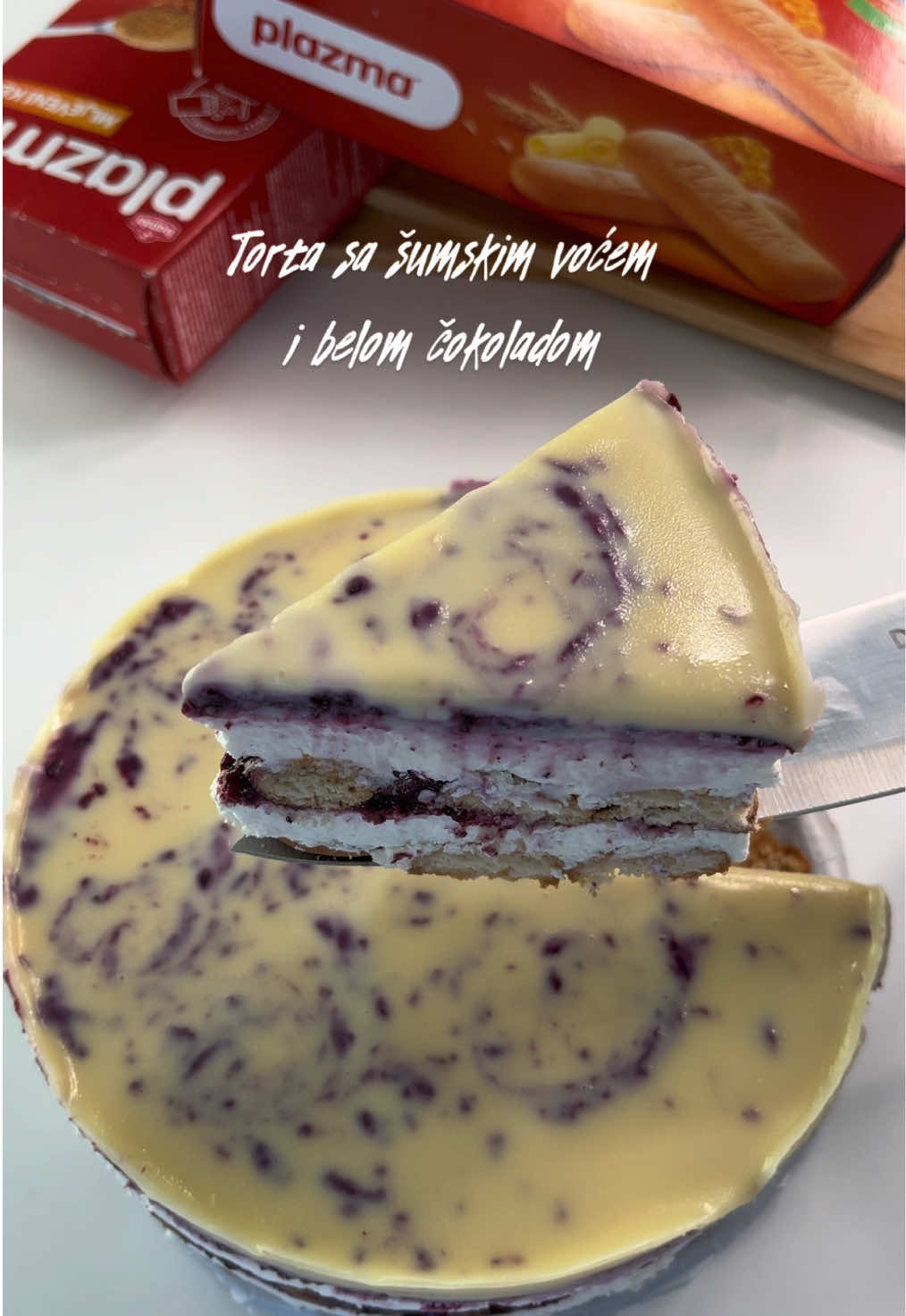 Torta sa šumskim voćem i belom čokoladom Fil: 300ml vrhnja za šlag 200gr krem sira 120gr bele čokolade (+50ml vrhnja za šlag) Fil od šumskog voća: 250gr šumskog voća  2 kašike šećera kašika gustina 50ml vode Korice: 180gr plazme malo mleka Preliv: 150gr čokolade  80ml vrhnja za šlag  Postupak: Fil od voća - prokuhati voće sa šećerom, izmiksati štapnim mikserom, a zatim u 50ml vode razmutiti kašiku gustina, preliti u voće i prokuhati još minut da se zgusne. Fil od bele čokolade - izmutiti vrhnje za šlag, dodati krem sir i dobro promešati kašikom, a zatim preliti istopljenim belom čokoladom i dobro sjediniti. (Čokoladu topite na pari sa 50ml vrhnja za šlag) U kalup redati plazma keks koji ste prethodno umakali u mleko.  Preko plazme premazati beli fil a zatim voćni, a zatim ponoviti postupak. Na kraju tortu prelijte belom čokoladom i po želji lagano čačkalicom pravite krugove kako bi dobili dekoraciju kao ja na videu.  Ostavite da odstoji minimalno 5h u frižideru pre serviranja. Prijatno! 🤗 #kuhajsaivanom #ivaninkutak #recepti #torta #sumskovoce @Plazma  @Plazma 