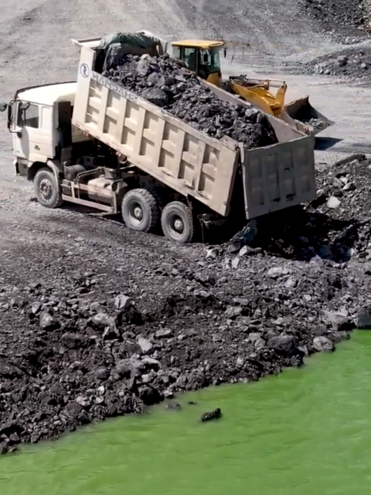 Wheels Loader SDLG Pushing Rock and Heavy Loading Dump Trucks working In construction projects