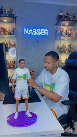 @Yewoyooh: @Yewoyooh: Voici le prompt : Créer une figurine commerciale à l'échelle 1/7 de (le personnage sur la photo), de style réalité dans un environnement réel.la figurine placée sur un bureau d'ordinateur .elle possède une base ronde en cristal violet transparente . a côté du bureau se trouve la vraie personne sur la photo , taille réelle, avec avec la même tenue que sur la photo et assis sur la chaise en nettoyant soigneusement la figurine avec une brosse fine dans une studio de style moderne, bien éclairé. avec une collection de jouets et de figurines et un cadre mural lumineux avec le mot Nasser en néon bleu en arrière -plan .gros plan mise au point nette.Résolution 8k. Ultra détail ultra Haute résolution détail complexe. La photo doit etre super nette et pas floue et en résolution 8k