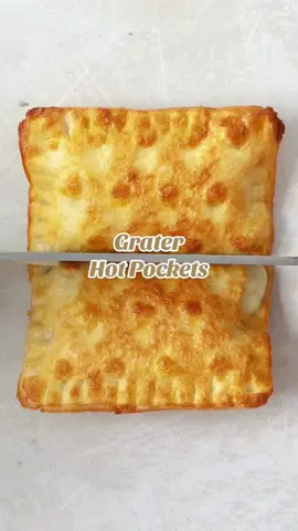Making ham & cheese hot pockets using a grater. Just press a couple of slices of bread into a grater, then cut into squares using the underside. Fill with ham and cheese and seal the edges with a fork. Brush with egg and toast until crispy and golden. Watch until the end to see what it’s like inside! #hotpockets #homemadehotpockets #foodhack #lunchhack #hamandcheesetoastie