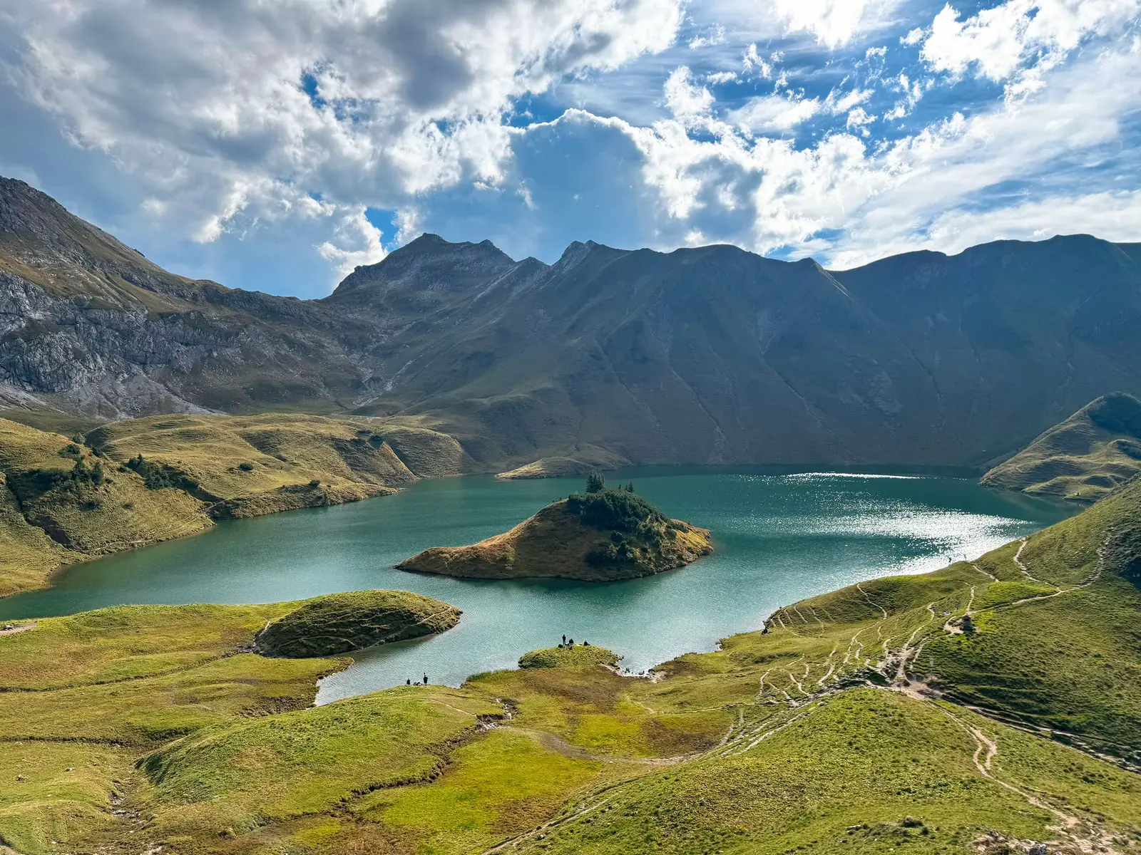 Am Sonntag den 21.09.2025 war ich am Schrecksee unterwegs und ehrlich: das war ein Erlebnis, das man nicht einfach so abhakt. Der Weg zieht sich schon ordentlich, aber genau das ist der Punkt – je weiter man geht, desto  mehr vergisst man das, was unten im Alltag so abgeht. Irgendwann bist du nur noch in den Bergen unterwegs, hörst deine Schritte, den Wind und hin und wieder ein paar Kuhglocken. Oben angekommen liegt dieser See einfach perfekt eingebettet zwischen den Bergen. Das Wasser ist so klar, dass man direkt reinspringen will (auch wenn’s gefühlt Eiswasser ist ❄️😅). Drumherum nur grüne Wiesen und neugierige Kühe, die einen anstarren, als hätten sie Hausrecht dort oben 🐄. Was ich mega fand: keine Autos, kein Straßenlärm, keine Ablenkung – einfach Ruhe. Man sitzt da, schaut über den See, die Berge im Hintergrund, und merkt, wie einem der Kopf plötzlich frei wird. Für mich definitiv einer dieser Orte, die man nicht so schnell vergisst. Kein Insta-Filter der Welt kommt an dieses Gefühl ran. #schrecksee #wandern #berge #hikingadventures #naturpur 