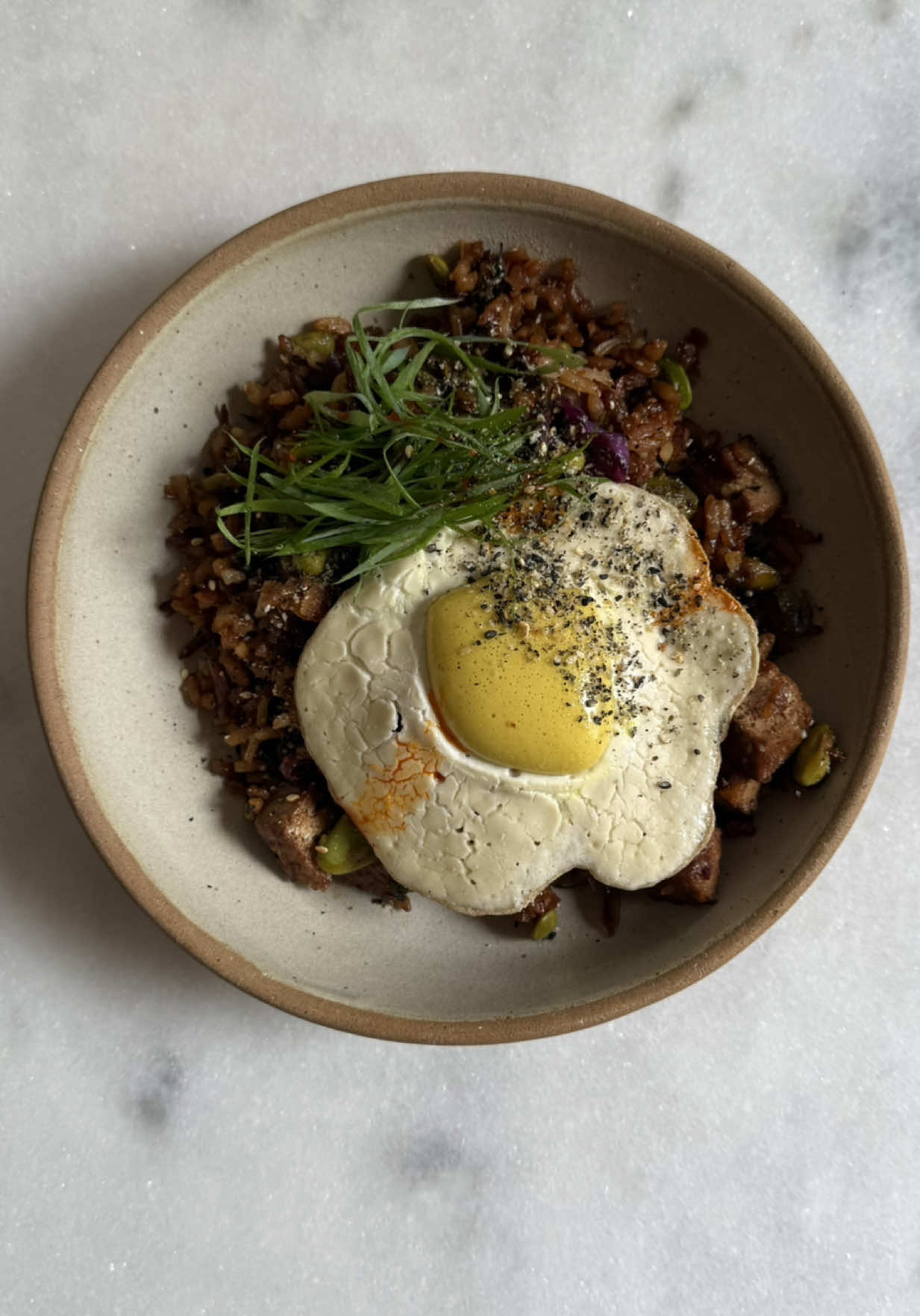 Ovo frito vegano  Ainda precisa de ajustes ein Banho de alginato:  1 litro de agua 7g de alginato de sódio Clara: 150g de tofu 30g de farinha de arroz glutinoso 80g de aquafaba 50g de creme de castanha sal negro Gema:  120ml de agua 107g de oleo 17g de amido de milho 4g de levedura nutricional 1g de cúrcuma 0,3g de goma xantana Sal negro 2g lactato de cálcio Modo de preparo: 1- Em um liquidificador, prepare o banho de alginato. Bata tudo e transfira para um recipiente. Armazene na geladeira por 12 horas antes de utilizar. 2- Clara: bata todos os ingredientes no liquidificador e reserve. 3- Gema: em um liquidificador, bata todos os ingredientes, com exceção do lactato de cálcio, até formar um líquido homogêneo. Adicione o lactato de cálcio e bata por mais um minuto.  4- Com uma colher, despeje o líquido no banho de alginato de sódio. Com a ajuda de duas colheres, cubra a “gema” com o alginato. Deixe por um minuto e depois transfira para um recipiente com água. 5- Para a montagem, adicione oleo ou azeite em uma frigideira e despeje o creme da clara. No centro, posicione a gema e deixe a clara fritar, como faria com um ovo. Sirva imediatamente #fy #fyp #vegano #ovo #receita 