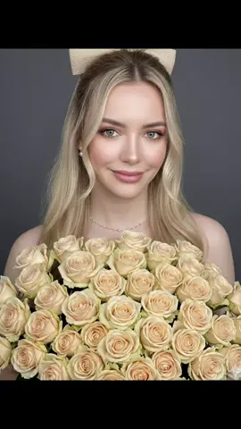 Gemini AI 🌼 Create a studio portrait of a woman with the same makeup as she wears in the photo. She holds a large bouquet of vibrant beige roses over her chest, making the flowers appear to serve as a blouse. She has long, soft, slightly wavy blonde hair, partially tied back with a large beige ribbon and the rest loose in front, and she wears pearl earrings and a delicate gold necklace. The background is a soft dark gray, and the overall lighting is soft and even, creating a clean, professional look. Make her face resemble the one in the submitted photo. #ai #gemini #fyp #IA #trend 