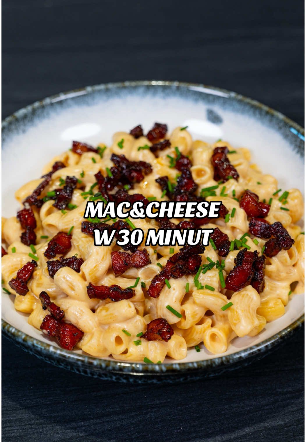 Obiady w 30 minut: Mac&Cheese z boczkiem 🧀 Przepis: Składniki: Mac&Cheese: 600 ml mleka 200 g makaronu - polecam kolanka ½ łyżeczki soli 1 łyżeczka wędzonej papryki 1/2 łyżeczki czosnku granulowanego 1/2 łyżeczki cebuli w proszku (lub tyle samo czosnku) 15 ml sosu worcestershire 80 g startego sera - np. gouda 70 g sera topionego w plastrach 20 g zimnego masła Boczek: 120 g surowego wędzonego boczku 15 g cukru brązowego 20 ml wody Przygotowanie: Mac&Cheese: 1. Na patelnię wlewamy mleko i sos worcestershire, wsypujemy makaron i przyprawy. 2. Włączamy średni ogień, a gdy mleko zacznie wrzeć zmniejszamy go i gotujemy makaron, aż będzie gotowy co jakiś czas mieszając. Powinno zająć to około 10-12 minut. 3. W międzyczasie ścieramy ser i dodajemy go na patelnię razem z serem topionym oraz zimnym masłem. Mieszamy na minimalnym ogniu, aż się roztopią. Boczek: 1. Boczek kroimy w kostkę i wrzucamy go na zimną patelnię. 2. Włączamy średni ogień i powoli smażymy go na chrupko 3. Dodajemy cukier brązowy, odrobinę wody i smażymy to jeszcze chwilę, aż cukier się roztopi. #coocharz #makaron #przepisy #macandcheese #jedzenie