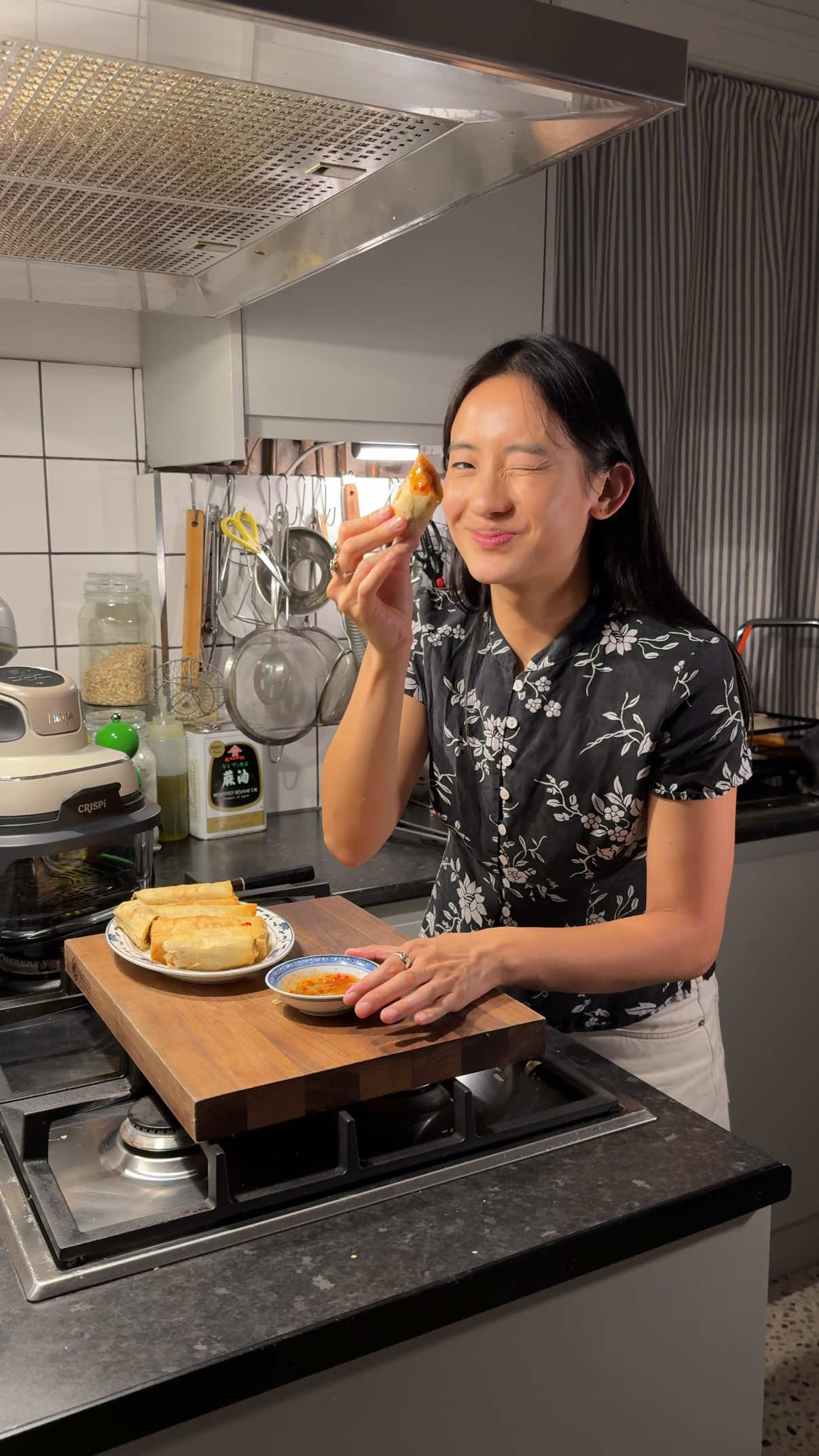 One of my favourite memories from mum’s old takeaway has to be the locals coming back every week for their favourite dishes, and a portion of spring rolls was always on the order. I’m gonna show you how I recreate those same, familiar flavours at home - and how I keep the leftovers just as good the next day with my @Ninja UK #NinjaCRISPi AD  Serves 4 For the pork filling: 240g pork loin 1 tbsp oyster sauce 1 tsp shaoxing wine ¼ tsp salt, sugar + white pepper ½ tsp sesame oil ½ tsp cornstarch  For the vegetable filling: 3 dried Chinese mushrooms 120g Chinese leaf 1 carrot 3 garlic cloves 50g vermicelli ¼ tsp salt, sugar + MSG ½ tsp white pepper 1 ½ tsp chicken powder 1 tbsp oyster sauce 1 tsp sesame oil 1 egg 12 spring roll pastry sheets Vegetable oil, to fry Sweet chilli sauce (essential) Soak the dried mushrooms in hot water for 10 mins. Thinly slice the pork loin, marinate with the seasonings and set aside. Finely slice the cabbage and carrot, transfer to a large bowl. Mince the garlic and set aside. Drain mushrooms, reserving the soaking water. Remove the stems, then slice. Soak vermicelli noodles in hot water until cooked. Cut into 4cm pieces with scissors, drain and rinse under cold water. Pour 3 tbsp of oil in the wok on medium heat, fry the garlic until slightly golden, then add cabbage, carrot, mushrooms and 3 tbsp of the reserved mushroom water. Stir-fry well. Add salt, MSG, sugar, pepper, chicken powder, oyster sauce, sesame oil and noodles. Stir to combine. Strain the cooked vegetable mix and let it cool. Meanwhile, beat the egg and separate pastry sheets, then cover with a damp cloth to prevent it from drying out.  Place a heaped tbsp of the filling near the corner of a pastry sheet. Fold in the sides, roll tightly, brush the top corner with egg, and finish rolling. Preheat your Ninja CRISPi on Air Fry mode, add the spring rolls in a single layer and lightly brush with oil. Air fry for 10 mins, flip, brush with a little more oil, and air fry for another 10 mins until golden and crisp. Serve hot with sweet chilli sauce.