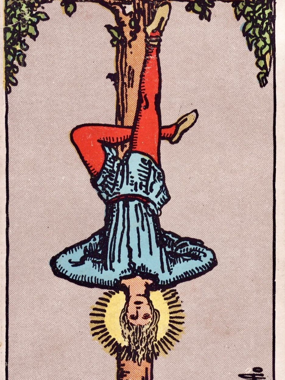 Arcano 12 - O Pendurado, do Tarot de Rider-Waite, 1909 (desenhado por Pamela Colman Smith). O Pendurado é uma carta de espera, que indica um momento de pausa e estagnação. No entanto, ela também nos convida a aproveitarmos esse período de suspensão para observar a vida a partir de um novo ângulo. O personagem principal está de cabeça para baixo… Uma posição desconfortável e inusitada, na qual não queremos permanecer por muito tempo… Ele também está de pés e mãos atados, mostrando que não há a nada a fazer a não ser ter paciência e esperar… Contudo, ele está de olhos abertos e há uma auréola iluminada ao redor de sua cabeça… Um símbolo de iluminação! Ou seja, já que ele está parado, ele aproveita para observar sua vida, refletir, rever suas prioridades… Embora seja difícil esperar nessa situação desconfortável, isso o faz crescer, ter ideias… O desconforto o ensinou sobre perseverança, foco e paciência. E, principalmente: mostrou os sacrifícios e mudanças que precisam ser feitas para colocar sua vida no eixo novamente. Em alguma hora, ele poderá se movimentar novamente… E quando esse momento chegar, se tiver aproveitado bem esse momento de pausa e reflexão, ele já saberá bem como entrar em ação.