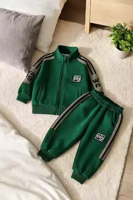 Setelan tracksuit anak laki-laki/perempuan ini hadir dengan desain sporty dan kasual, sangat cocok untuk aktivitas sehari-hari maupun berolahraga. Terdiri dari jaket berresleting dengan kerah tinggi dan celana panjang senada, keduanya berwarna hijau gelap dengan aksen garis hitam dan abu-abu di bagian lengan dan samping celana. Terdapat detail tulisan 