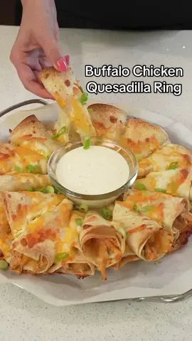 Turn up the heat for your next party or game day with these easy, flavor-packed Buffalo Chicken Quesadilla Rings! 🌶🧀  Buffalo Chicken Filling Ingredients:  4 - 5 oz. Omaha Steaks Air-Chilled Boneless Skinless Chicken Thighs, cooked and shredded, about 4 cups (You can also use chicken breasts)  4 ounces cream cheese  1/3 cup Buffalo sauce  1 teaspoon onion powder  1 teaspoon salt  1/2 teaspoon black pepper  Buffalo Chicken Quesadilla Ring Ingredients:  14 flour tortillas, cut in half  4 cups shredded Mexican cheese  Sliced green onion, for garnish  Blue cheese or ranch dressing, for dipping.  Buffalo Chicken Filling Directions:  1. Mix all ingredients together in a large bowl until well combined.  Buffalo Chicken Quesadilla Ring Directions: 1. Preheat your oven to 400 degrees.  2. Spread a spoonful of the buffalo chicken mixture on the tortilla half, then sprinkle with cheese.  3. Roll the tortilla in a cone shape.  4. Arrange the cones in a circle shape on a baking sheet, sprinkling more shredded cheese in between the cones. Top with another layer of cones, then more cheese.  5. Bake for about 10-15 minutes until the tortilla edges are golden brown and the cheese has melted.   6. Place a bowl of ranch or blue cheese in the center of the ring for dipping and sprinkle the ring with sliced green onion.  📸 Couple in the Kitchen