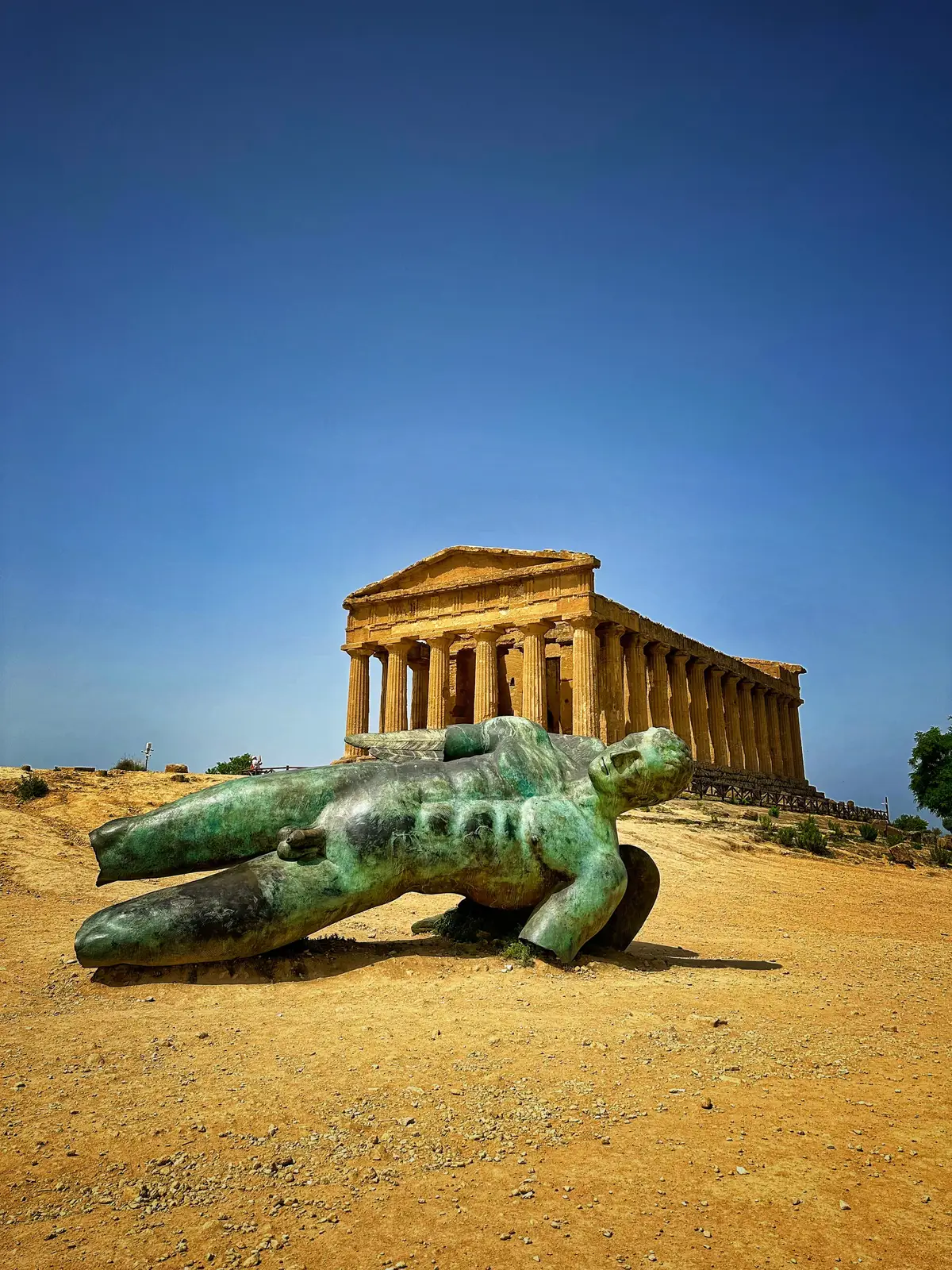 An ancient god lies fallen before the Temple of Concordia in Agrigento, Sicily. A reminder that even myths rest under the same sun.   #ValleyOfTheTemples #SicilyVibes #AncientRuins #TempleOfConcordia #SicilianSummer 