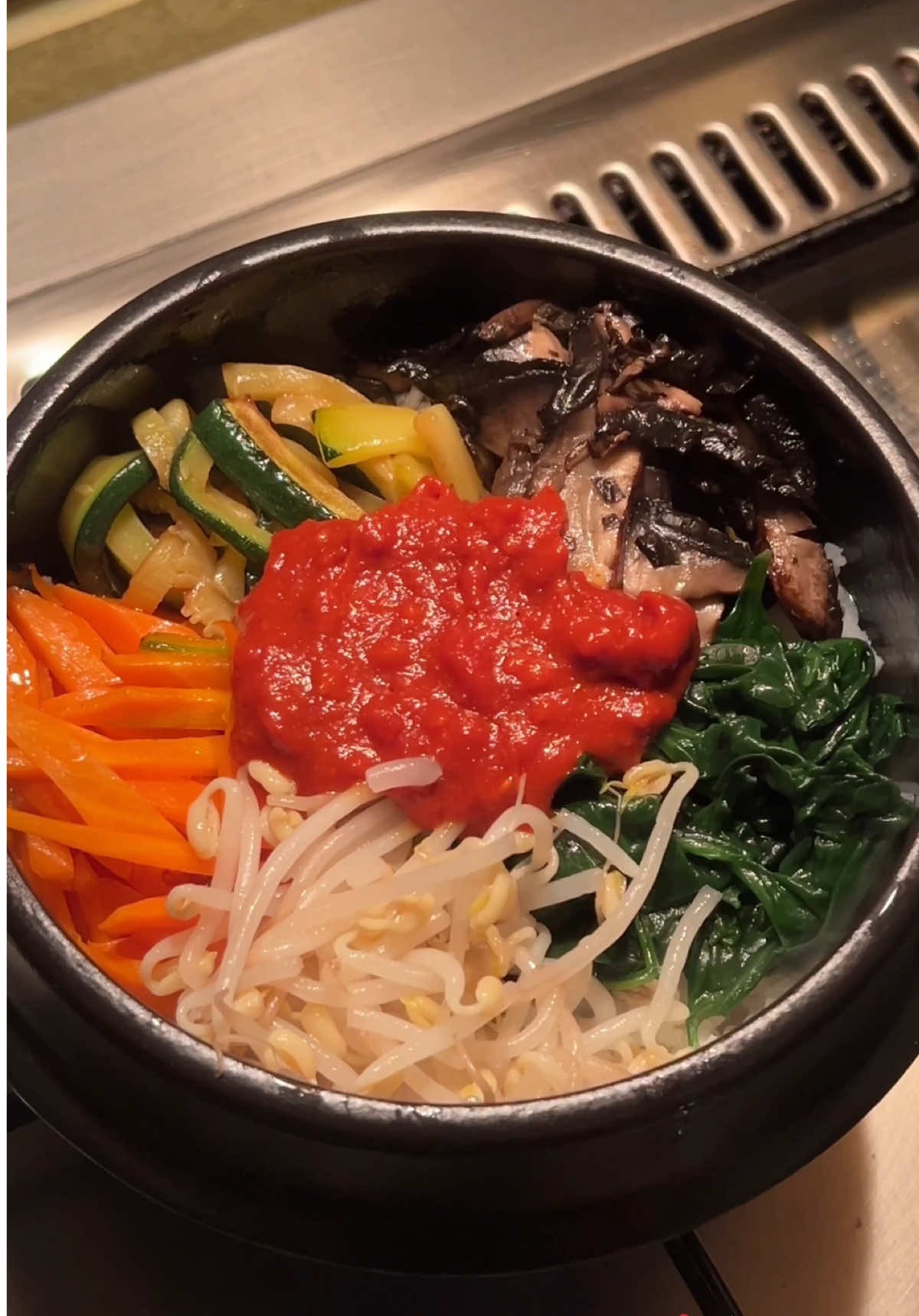 Ingredients: Sauce: 2 tbsp gochujang (Korean red pepper paste) 1 tsp sugar 1 tsp garlic, minced 1 tsp sesame oil 2 tsp sesame seeds (optional) Vegetables & Rice: Cooked short-grain rice 1 carrot, peeled and julienned 1 zucchini, julienned 2 handfuls spinach 1 handful bean sprouts 4 large shiitake mushrooms (or any mushrooms), sliced Sesame oil Salt Make the sauce: Mix gochujang, sugar, garlic, sesame oil, and sesame seeds in a small bowl. Set aside. Blanch spinach and bean sprouts; season with salt and sesame oil. Stir-fry carrot, zucchini, and mushrooms with sesame oil; season. Brush a bowl with sesame oil, add rice, arrange vegetables on top, and place sauce in the center. Optional: heat 5–10 mins for crispy bottom. Mix before eating. Mix well and enjoy! ♥️ . . . . . . #bibimbap #kfood #atfrankfurt 