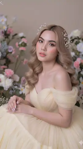 Prompt: A dreamy, romantic portrait of a young woman surrounded by soft pastel flowers, sitting gracefully in a delicate pose. She wears a flowing off-shoulder gown made of sheer pale yellow tulle, with layers of soft fabric creating a light and ethereal look. Her long wavy hair cascades down naturally, decorated with small delicate flowers tucked into the strands. Makeup is flawless and doll-like: glowing porcelain skin, soft blush on the cheeks and nose, glossy pink lips, and large luminous eyes with long eyelashes, giving her an enchanting and fairy-like beauty. Her long manicured nails are elegantly styled, enhancing the sophisticated vibe. The soft studio lighting creates a gentle, glowing atmosphere with no harsh shadows, making the skin appear smooth and radiant. The background is filled with blurred pastel flowers (white, pink, and cream tones), enhancing the dreamy, romantic, and fantasy-like mood. By using the extract same face from the reference image.#fyp #Prompt #ai #gemini #geminiaiprompt 