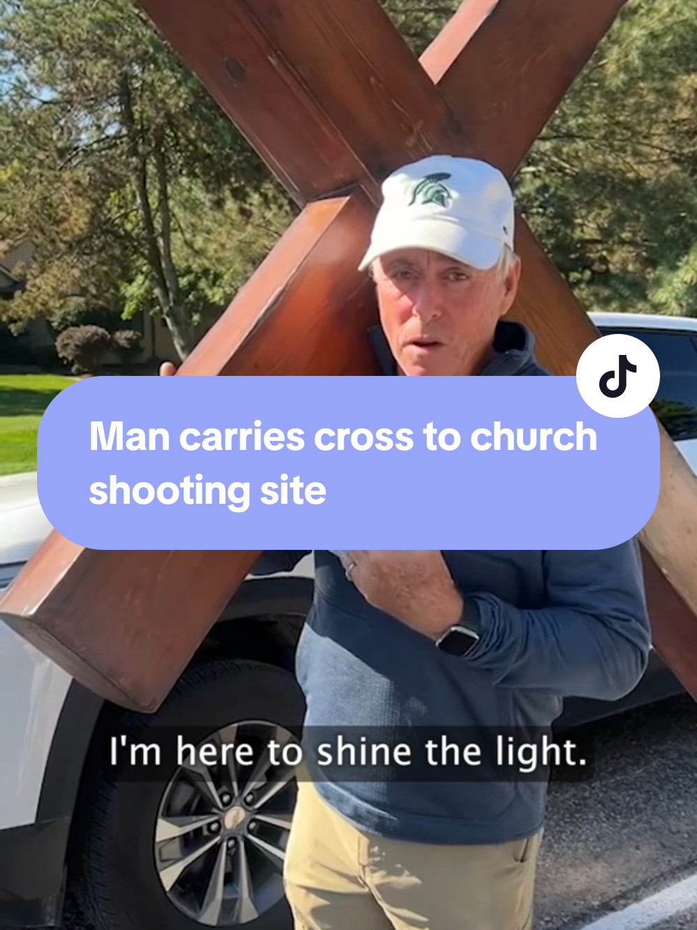 Michigan native Dan Beazley carries a massive wooden cross to the site of a deadly church shooting in Grand Blanc Township. Beazley has carried the cross to recent tragedies across the country to shine a light “over a dark situation.