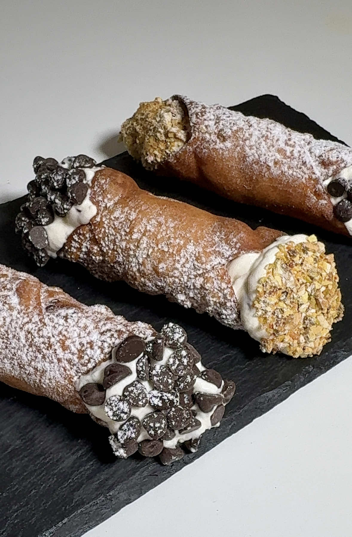 #C ANNOLI 🤌🏻🍫 ✨ Bienvenidos a CLICHÉ A LA CARBONARA, el viaje por la gastronomía italiana de la A a la Z… sin pasta ni pizza. Hoy aterrizamos en Sicilia, donde el dulce se convierte en leyenda: los cannoli siciliani. Y si te digo que este dulce tiene más historia que tu abuela contando batallitas? ¿Y si te cuento que su origen es tan antiguo como el arte de freír? 🧁 Ingredientes (para 12 cannoli): Para la masa: •250 g de harina (más un poco para espolvorear) •1 cucharadita rasa de cacao amargo en polvo •50 g de azúcar •30 g de manteca de cerdo (o mantequilla blanda) •1 huevo batido (usar la mitad para la masa y la otra mitad para sellar los cannoli) •1 chupito de Marsala (unos 60 ml) •1 cucharada de vinagre de vino blanco •Canela en polvo •Vainilla (1 sobre o 1 cucharada de extracto) •3 g de sal •Aceite para freír Para el relleno: •800 g de ricotta de oveja bien escurrida •300 g de azúcar •120 g de gotas de chocolate negro Para decorar: •Azúcar glas •Pistachos triturados •Gotas de chocolate •Naranja confitada (opcional) 🔥 Cómo se hace: 1️⃣ Masa: Mezcla la harina, cacao, azúcar, sal, canela y vainilla. Añade la manteca, el huevo, el vinagre y el Marsala. Amasa hasta obtener una masa lisa y homogénea. Deja reposar 60 minutos en la nevera 2️⃣ Formado: Estira la masa hasta que quede muy fina. Corta cuadrados y enrolla cada uno alrededor de un tubo de metal (cilindro para cannoli). Sella los bordes con el huevo batido 3️⃣ Freír: Calienta el aceite a 170°C y fríe los cannoli hasta que estén dorados. Retira y deja enfriar 4️⃣ Relleno: Mezcla la ricotta escurrida con el azúcar hasta obtener una crema suave. Incorpora las gotas de chocolate 5️⃣ Montaje: Rellena los cannoli con la crema de ricotta y decora con pistachos, naranja confitadachocolate y una pizca de azúcar glas. Porque al final… quién dijo que Italia solo era pasta y pizza? #ClicheALaCarbonara #ItaliaDeLaAaLaZ #CannoliSiciliani #postre 