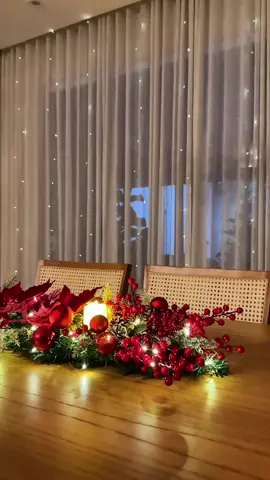 Inspiração para centro de mesa natalino 🎄🎅 Para a produção foi utilizado um festão aramado dobrado ao meio para ficar no tamanho desejado, 4 flores, picks, bolinhas, 2 velas de led e os fios de fada que dão um charme. #decoracaodenatal #natal #centrodemesa #natal2025 #natalina 