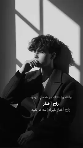 #gemini  الكليشة ‏ black-and-white aesthetic portrait of a stylish meluse my image with accurate face 100% sitting on the floor in dramatic lighting. He is wearing an oversized dark coat, with messy, voluminous hair partially covering his face. His pose is emotional and introspective, with one hand near his mouth and his head slightly turned to the side. Shadows from a window tall across the wall behind him, creating a moody and artistic atmosphere. The overall vibe is mysterious, emotional, and cinematic.