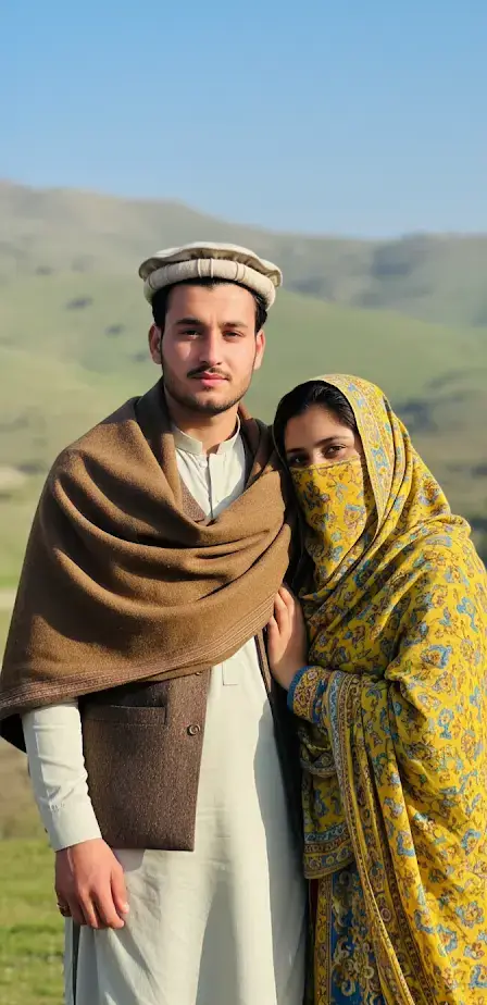 {PROMT}👇💞 Create a image with attached photo(100% accurate face) A young couple in Pashtun traditional attire posing outdoors with a soft, natural background. The man wears a shalwar kamees with pakol and waistcoat and a Brown shawl draped over his shoulders. He looks at the camera. The woman, wearing a hijab burqa with niqab of yellow blue colour, leans gently against the man, holding his arm. She looks directly at the camera with a gentle expression. Note: Use the provided photos of on-screen reference. The face must match the photo exactly and without any changes in face or hairs no alterations, no digital changes, no heavy makeup. Preserve facial proportions, scars/moles, and natural expression. #gimini#app #Googlegiminiapp#foryoupage#justforfun