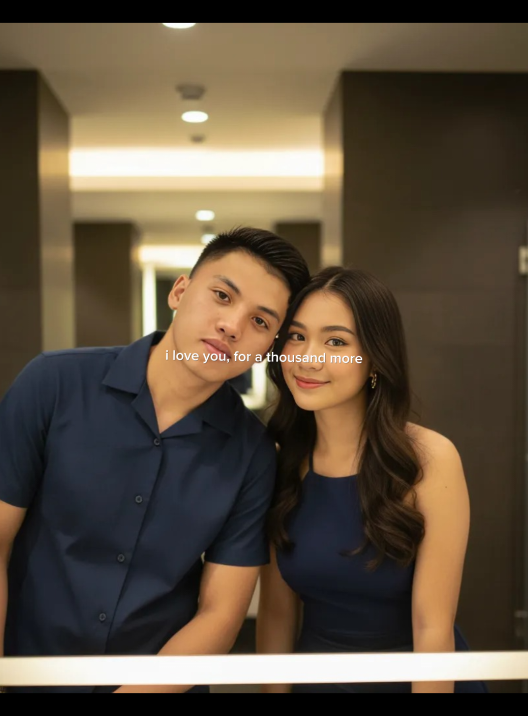 Here's the prompt couples ✨🫶🏻 Change the picture to a realistic portrait. A young couple took a selfie in front of a modern bathroom mirror with dark colored walls.like a bathroom mall. LED bright white horizontal at the top of the mirror, gives a soft lighting effect on the face and clothes.at the bottom looks white sink with metallic tap and stainless steel soap dispenser.photo casual style.looks real, HD quality, clear details and still maintain the original face without change #fyp #foryoupage #geminiaiprompt #gemini #COUPLE 
