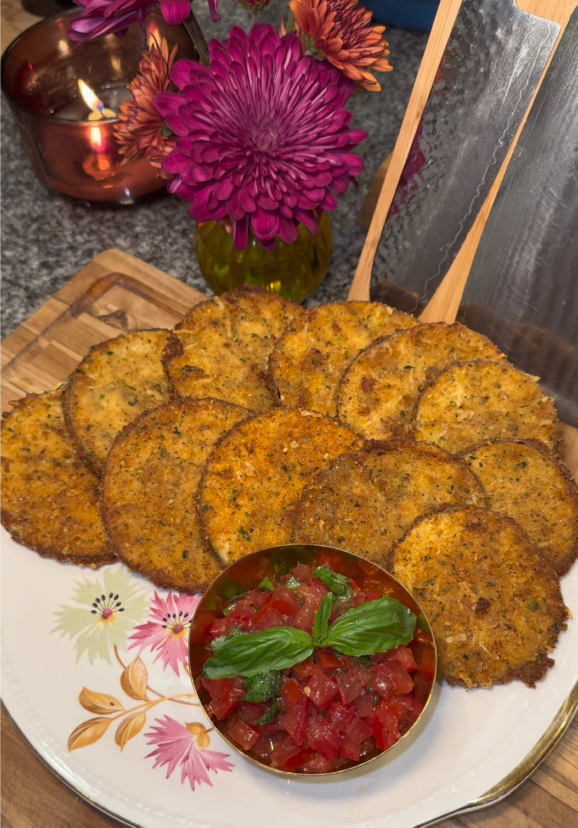 My Sicilian Grandmother’s Fried Eggplant🍆 Start out by getting an eggplant and cut it into rounds. (You want them to be about a quarter inch thick.) Add water and salt to a large bowl, and soak the eggplants for 1 to 2 hours, using a plate to make sure they’re submerged. (This process gets out the bitterness in the eggplant)  Pat them dry with a paper towel when they’re done soaking.  Then add flour to one plate, and 1 part Italian breadcrumbs and 1 part Parmesan cheese to another plate.  Season both plates with whatever like. (Today I’m using Greek seasoning, garlic powder, chicken bouillon and pepper.) Then dip each eggplant round into the flour, then into whisked eggs, and pack on the breadcrumbs.  Fry them in high heat oil (heated to about 320 degrees) til they’re golden brown, letting them rest on a cooling rack.  For parties, it’s fun to serve them with this bruschetta topping.  To make this, get 5 Roma tomatoes and remove the center and seeds.  Then dice them up and them to a bowl with: -about 1/3 cup of fresh chopped basil  -3 tablespoons of olive oil -salt and pepper to taste  Stir it together and serve it on the side with your eggplants. It’s delicious to also top them with some balsamic glaze.  Enjoy💜  #Recipe #friedeggplant #eggplant #food #foodtiktok 