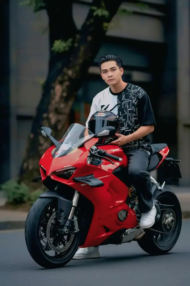 𝙋  𝙋𝙧𝙤𝙢𝙥𝙩 : Potret luar ruangan dinamis - Foto resolusi tinggi, tembakan menengah [orang referensi di foto] duduk pada sepeda motor sport Ducati merah. [orang referensi di foto] melihat langsung ke kamera dengan ekspresi percaya diri, memegang helm wajah penuh hitam dan merah. [menjaga karakter rambut di foto]. Dia mengenakan T-shirt unik kiri putih kanan hitam, celana jeans gelap, dan sneakers putih. Pengaturan jalan kota dengan latar belakang gelap yang kabur, menampilkan batang pohon dan fasad bangunan halus. Kamera: DSLR full-frame, lensa 85mm, kedalaman lapangan dangkal, sudut yang sedikit rendah. Pencahayaan: pencahayaan yang lembut dan alami, menciptakan bayangan halus. Mood: percaya diri, bergaya, elegan, urban. Palet warna: merah tebal, hitam dalam, abu-abu gelap, dengan hijau halus Gaya/detail: hiperrealistis, fokus tajam pada subjek dan sepeda motor, tekstur yang sangat rinci, 8k Setelah pemrosesan: peringkat warna alami, kontras tinggi pada sepeda motor. Pesan negatif: teks pada produk, tanda air, anggota tubuh tambahan, warna yang terlalu memuaskan, elemen kabur yang mengganggu, fitur kartun. #chatgpt  #fyppppppppppppppppppppppp  #prompt  #googlegemini  #foryou 