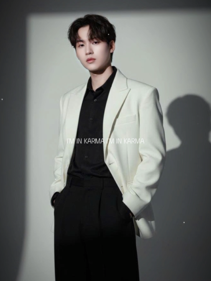 1. Open gemini 📲 2. Upload your photo 📸 3. Paste the prompt 👇 A young man standing indoors against a minimal studio backdrop. He wears a loose white blazer over a buttoned black shirt, paired with wide black trousers. The blazer has structured shoulders and flap pockets, while the black shirt inside adds contrast and elegance. His right hand is raised, slightly touching his forehead as if shielding his eyes from the light, while his left hand rests casually in his pocket. His hairstyle is slightly tousled, medium length, dark, and textured. Dramatic studio lighting casts a sharp rectangular light frame on the wall behind him, creating strong shadows that emphasize his silhouette. The mood is elegant, minimalist, and cinematic, with soft but contrast-rich tones, high-resolution fashion photography style.#CapCut #xuhuongtiktok #photongai #viral #LearnOnTikTok 