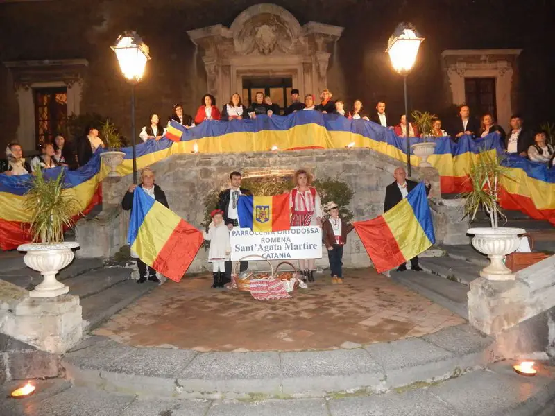 Români din patru unghiuri, acum ori niciodată Uniţi-vă în cuget, uniţi-vă-n simţiri! Trăiască România!  a răsunat și din insula Siciliei. Miercuri, 5 decembrie, Consulatul Român din Catania, a celebrat 100 de ani de la Marea Unire din 1918, la Palatul Biscari, unde au fost prezente oficialitațile cetății de la poalele vulcanului Etna. La recepție, centenarul a unit autoritățile italiene cu personalitățile de seamă ce se află în fruntea românilor ce trăiesc și muncesc în Sicilia. Seara a debutat cu intonarea imnului României și al Italiei. În alocuțiunile lor doamna consul Liliana Iacob și domnul consul Ioan Iacob, au mulțumit statului gazdă, pentru sprijinul acordat integrării compatrioților lor, în societatea italiană, subliniind realizările comunitații în insulă. Oficialii italieni au evidențiat în cuvântările lor, contribuția importantă, a celei mai numeroase pături emigrante, în număr de peste un milion și jumătate, la dezvoltarea țării. Ambasadorii cântului românesc au fost în acest an artiștii Gheorghe Turda și Nicoleta Voicu, care au oferit asistenței un impresionant buchet de cântece populare. Ca în fiecare an, părintele Mihai Gabriel Ichim de la parohia ”Sfânta Muceniță Agata” din Catania a reprezentat Biserica Ortodoxă Română, iar un grup de enoriași, prin joc și cânt, a contribuit cu succes la realizarea unui program, ce a adus România în sufletele tuturor celor prezenți. Un frumos tort simbolic, a fost oferit, spre a celebra acest important moment din istorie. La mulți ani, România! La mulți ani, români, oriunde ați trăi pe pământ!