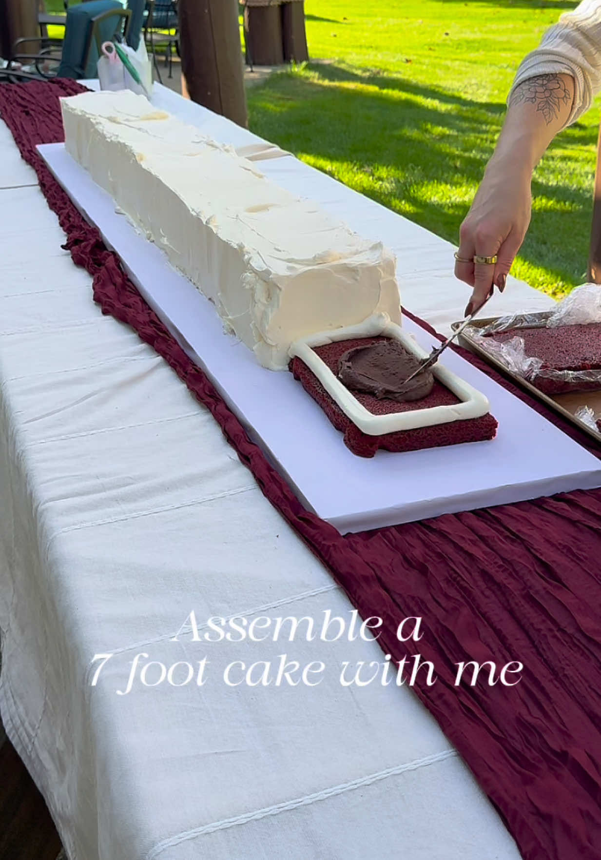 Assemble another 7 foot centerpiece cake with me!!! These are quickly becoming my favorite cake style to do because they are sooo versatile! This one was a super moist red velvet cake with chocolate ganache filling to match the burgundy vibes.  *my hands were super clean and washed very thoroughly and between steps *the florals have clear floral tube picks on the ends so they aren’t directly in the cake  Planning: @Morgan Gates | Wedding Content  Table design: @Roni | Event Planning & Design  #longcake #cakedecorating #viralcake #weddingcakeinspo #cakeinspo