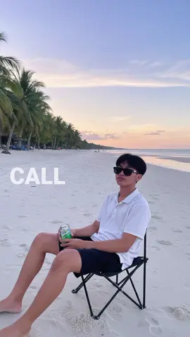 #CapCutAI Gemini prompt:Using the model, create an outdoor photograph with 17 years old boy with the same face shape, nose, eye, lips, brows, hair placement is the same placement and the skin in the photo that i upload taken in the late afternoon, In the photo, l am sitting on camping chair with a side view, but my face is in front of camera by a tranquil beach. wearing a plain white Hawaiian polo , wearing a plain black hawaiian short , wearing summer eye glasses, not wearing slipper just a foot .Holding a sprite can.Background, A vast white beach with the reflection of the sky.a clear evening sky with thin clouds. There are coconut Trees on side of the beach .They are sitting on well-kept white sand .Photo Style, Outdoor Portrait, casual style, with natural dusk lighting. The overall impression is relaxed and peaceful.@Gemini AI