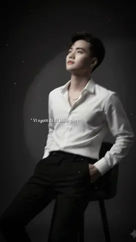 Wdu B1:gemini B2:chọn ảnh B3:dán câu lệnh Một bức chân dung siêu thực đậm chất điện ảnh về một chàng trai trẻ đứng dưới mưa, tay cầm chiếc ô trong suốt. Mái tóc đen ướt của anh buông tự nhiên trên trán, những giọt mưa lấp lánh trên khuôn mặt. Anh mặc một bộ vest xanh navy sẫm bóng bẩy, được may đo vừa vặn và thanh lịch, bên trong là chiếc áo sơ mi trăng tinh, không cài cúc ở trên cùng, tạo nên vẻ ngoài thoải mái nhưng tinh tế. Anh không đeo cà vạt, toát lên vẻ tôi giản và hiện đại tinh tế. Một chiếc trâm cài bạc hình học tinh tế được cài trên ngực. Tay kia, anh cầm chắc một tập tài liệu da đen, toát lên vẻ thông thái và mục đích. Bầu không khí u ám và kịch tính, với mưa rơi nặng hạt khắp nơi, nhưng chiếc ô tạo nên một lớp vỏ điện ảnh mềm mại. Bảng màu xanh lam lạnh lẽo, độ tương phản cao và chi tiết sắc nét khiến hình ảnh trông như một cảnh tĩnh từ một bộ phim tân-noir. Biểu cảm của anh trầm ngâm và hơi u sầu, ánh mắt nhìn chằm chẳm hướng lên trên như thể đang chìm đắm trong sự chiêm nghiệm sâu săc#xuhuongtiktok2024  * #xuhuongtiktok2025 